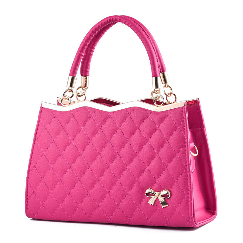 Pink handbag with a bow detail on a white background