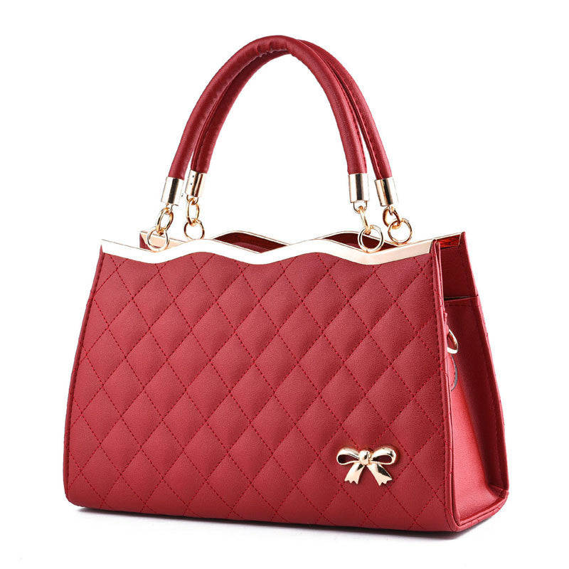 Red quilted handbag with a bow detail on a white background