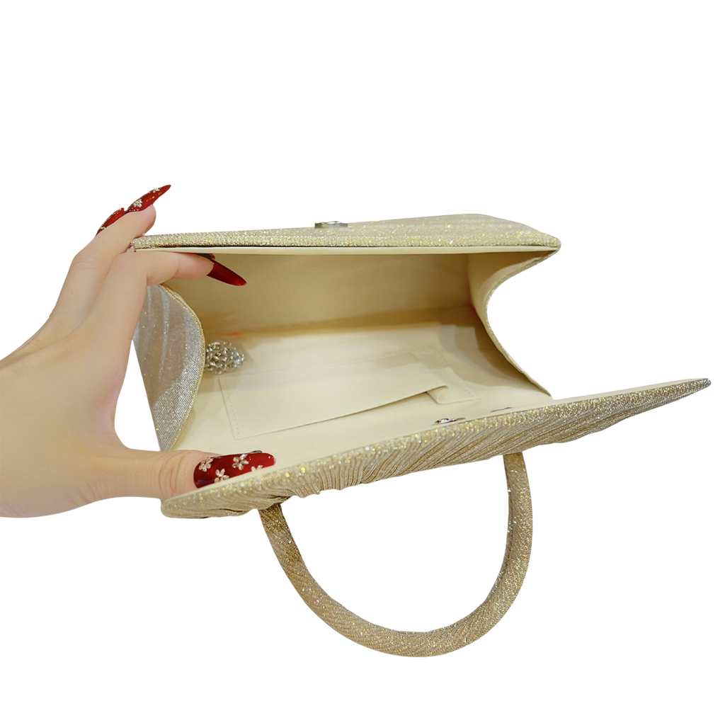 Beige clutch bag held open by a hand with red nail polish on a white background