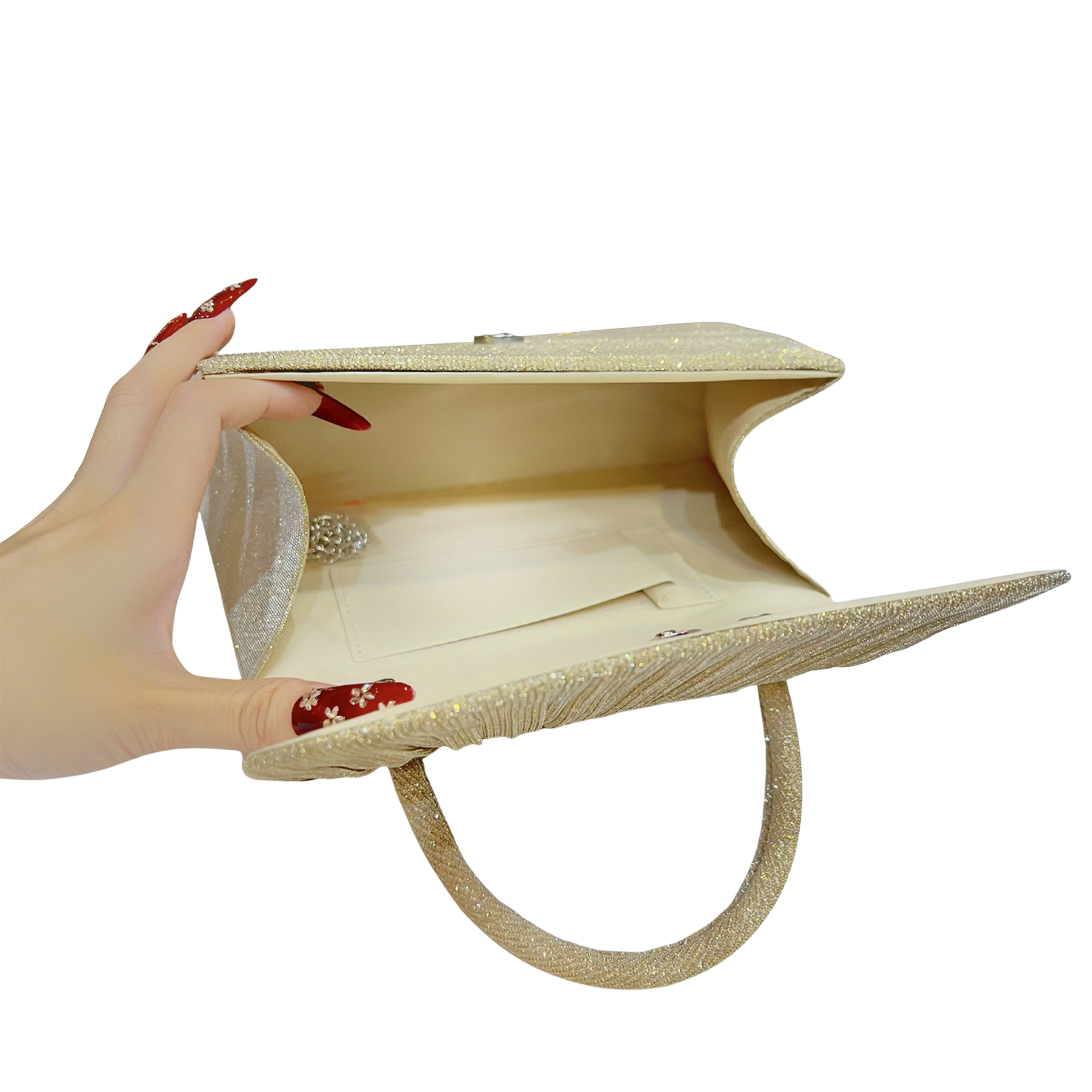 Beige clutch bag held open by a hand with red nail polish on a white background