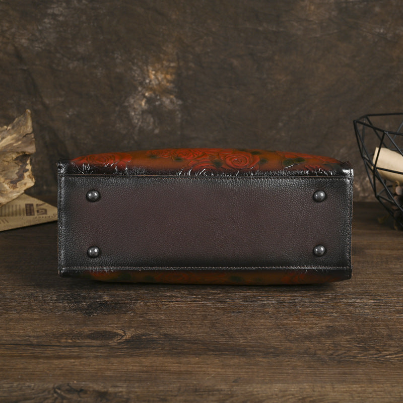 Brown leather wallet with floral pattern on a wooden surface
