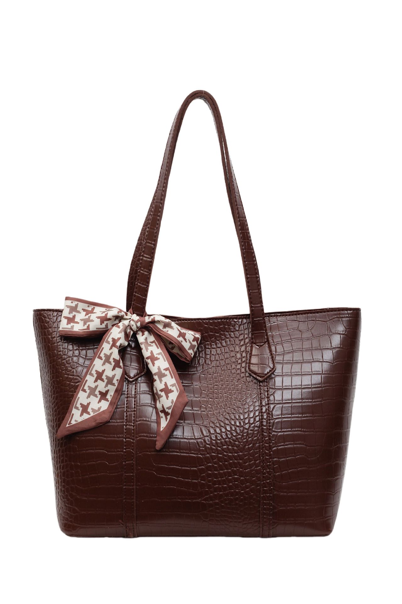 Brown textured handbag with a decorative bow on a white background