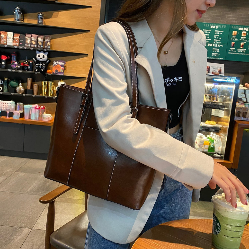 Women wearing a brown leather bag at starbucks before she heads to work