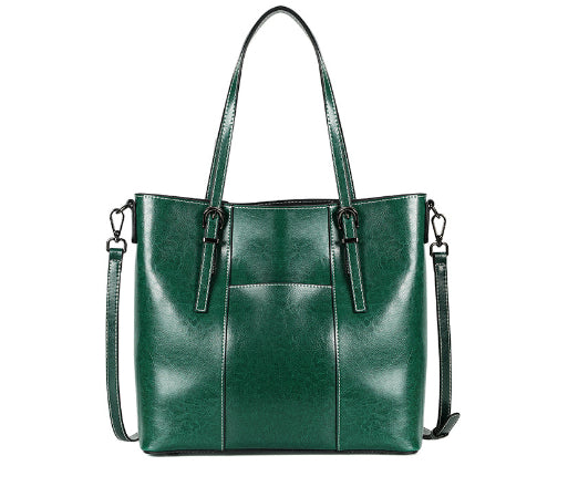 Green leather handbag with a shoulder strap on a white background