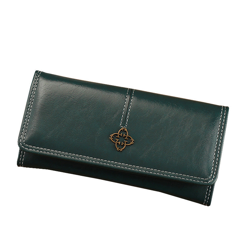 Green leather wallet with a decorative clasp on a white background