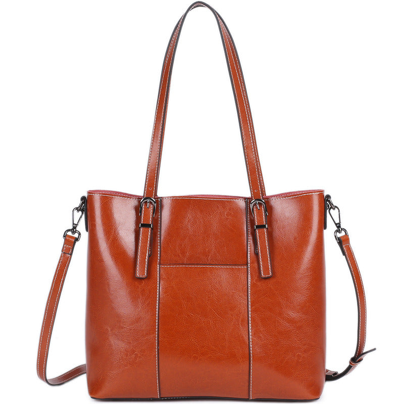 orange leather tote bag with shoulder strap on a white background that can fit a laptop
