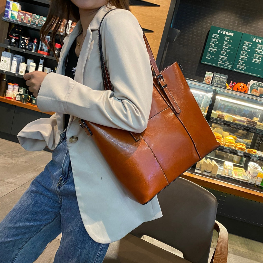 Person holding a orange leather bag in a store setting