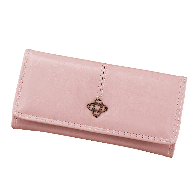 Pink wallet with a decorative charm on a white background