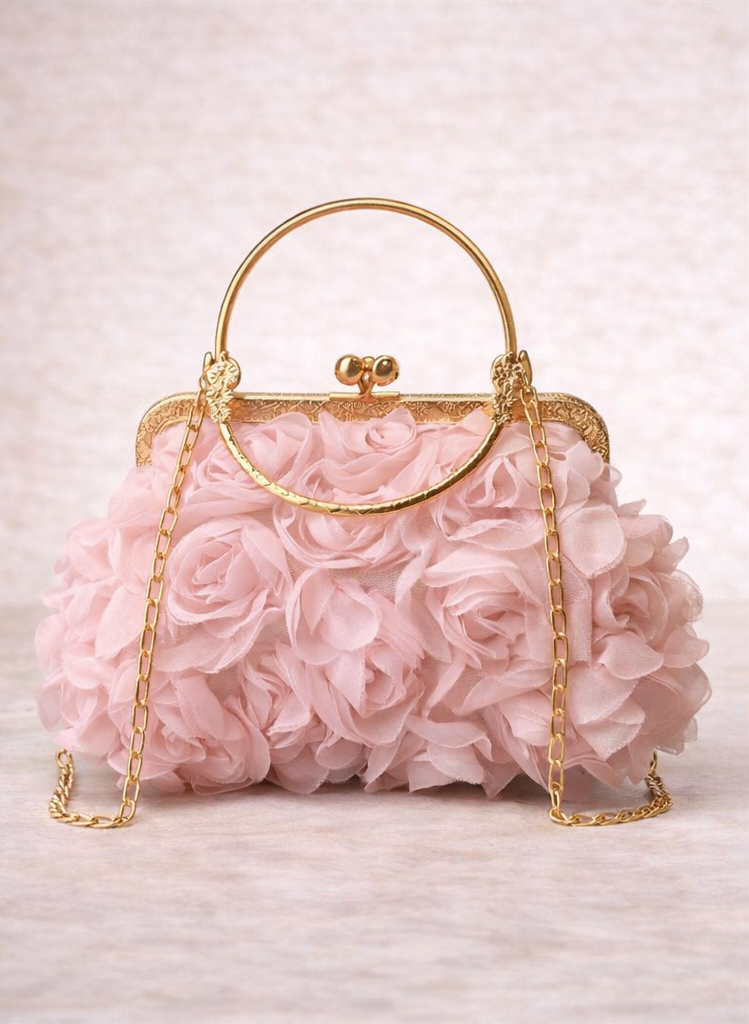 Pink floral handbag with gold accents on a light pink background