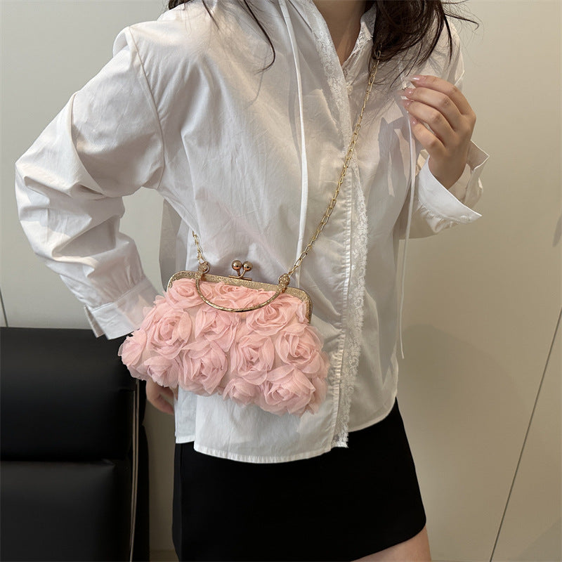 Perso wearing a pink floral handbag as a crossbody with a white shirt and black skirt.