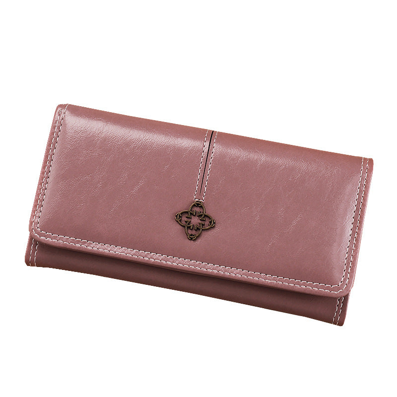purple leather wallet with a decorative charm on a white background
