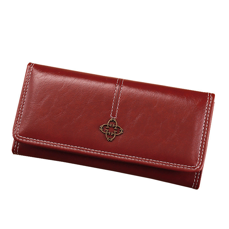 Red leather wallet with a decorative charm on a white background